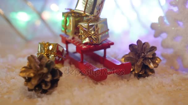 Schachteln mit Geschenken auf dem roten Spielzeugschlitten Weihnachten Hintergrund — Stockvideo