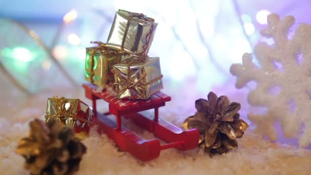 Cajas con regalos en el trineo de juguete rojo Fondo de Navidad — Vídeo de stock