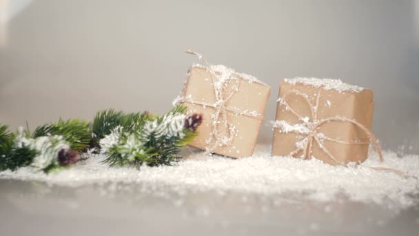 Karácsonyi ajándékok és ágai, a hóban egy fehér háttér dobozok — Stock videók