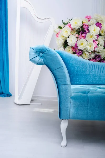 Türkisfarbenes Sofa und ein Blumenstrauß im Studio — Stockfoto