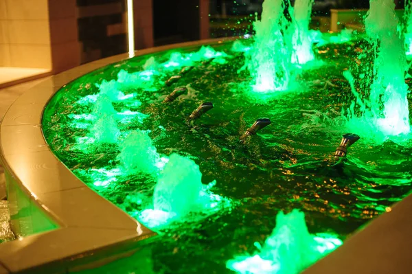 Färgglada upplysta fontäner på natten i staden — Stockfoto