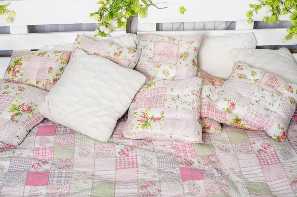 Hoofdkussen en dekens op het bed in rustieke — Stockfoto