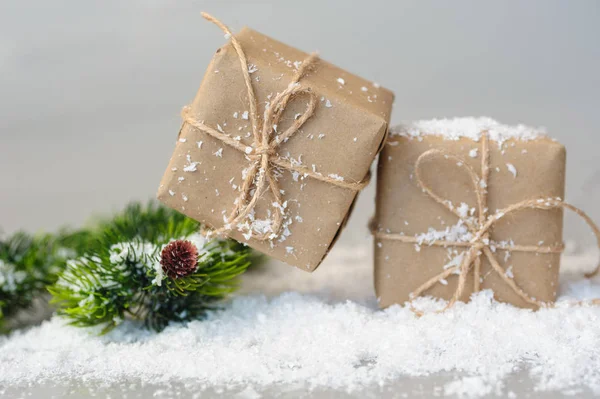 Caixas de presente e galhos de abeto na neve — Fotografia de Stock