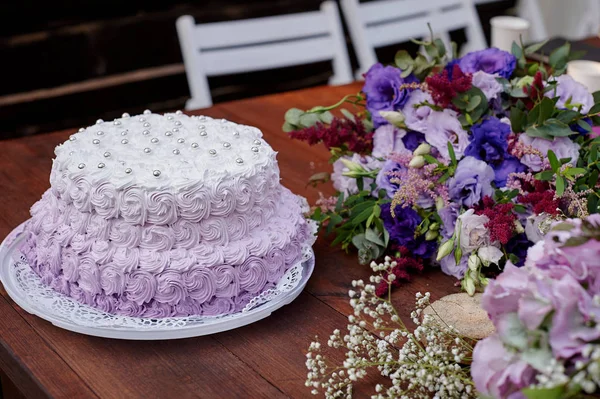 Uroczysty tort weselny i bukiet kwiatów na stole — Zdjęcie stockowe