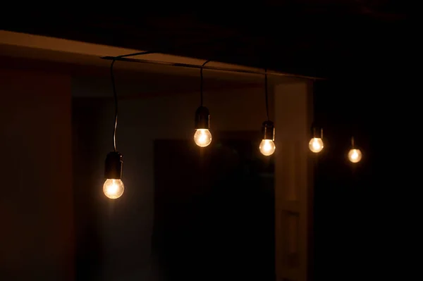 Cinco bombillas incluidas en una habitación oscura — Foto de Stock
