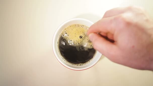 Homem mexe café em uma xícara na mesa — Vídeo de Stock