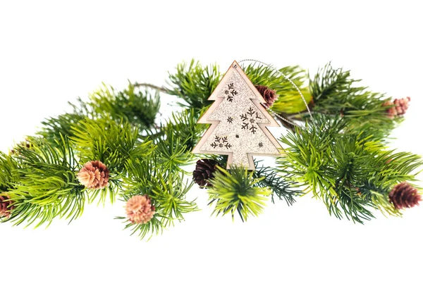 Fir branches with cones and wooden toys on white background — Stock Photo, Image
