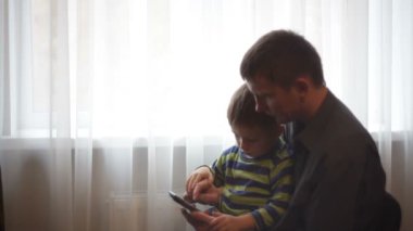 Baba ve oğul telefon ile oturuyor