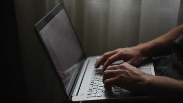 Young man sits at a laptop — Stock Video