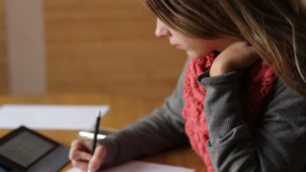 Bela jovem mulher no escritório escreve com caneta — Vídeo de Stock
