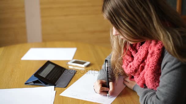 Красивая молодая женщина в офисе пишет ручкой — стоковое видео