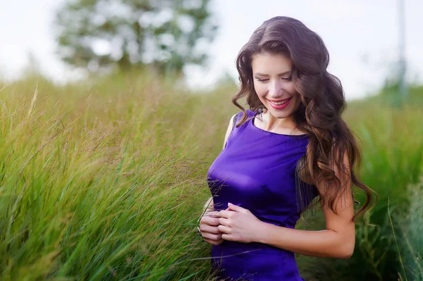 Jovem mulher em vestido roxo andando no parque de verão — Fotografia de Stock