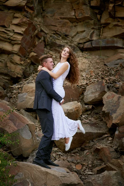 Braut und Bräutigam umarmen sich in den Bergen — Stockfoto