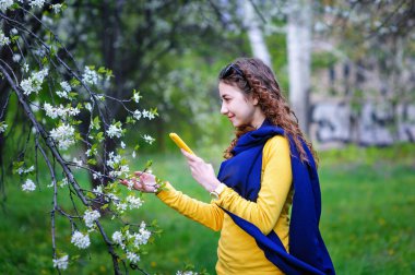 telefonunuzla parkta yürüyen güzel genç kadın