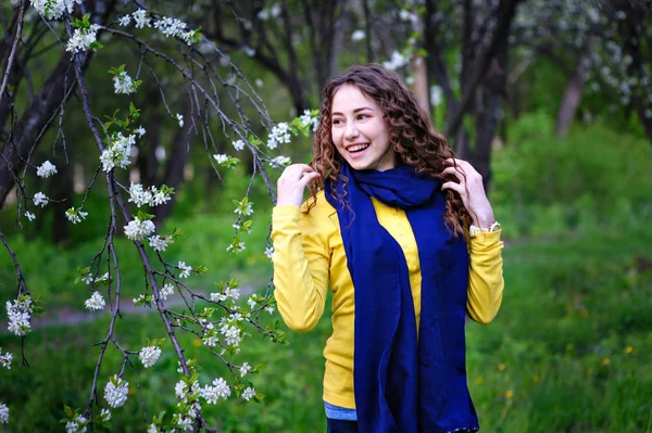 Glad ung kvinna promenader i den blommande våren trädgården — Stockfoto