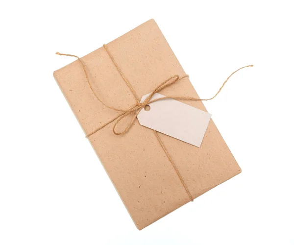 Kraft paper gift box with a label on white background — Stock Photo, Image