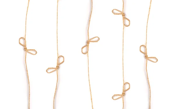 Lines flaxen ropes with bows and knots on a white background — Stock Photo, Image