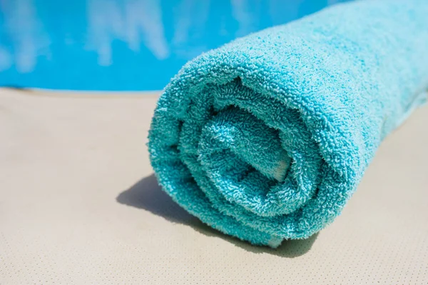 Turquoise towel lies on the edge of the pool — Stock Photo, Image