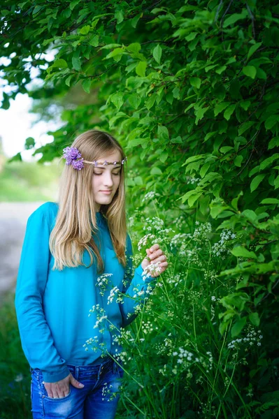 彼女の頭に花輪を捧げると若い美しい女性が夏公園を散歩します。 — ストック写真