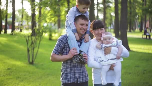若い家族が夏の公園で草の上歩く — ストック動画