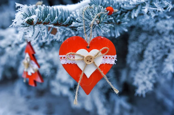 Houten Christmas speelgoed op een mooie besneeuwde spar boom in de winter — Stockfoto