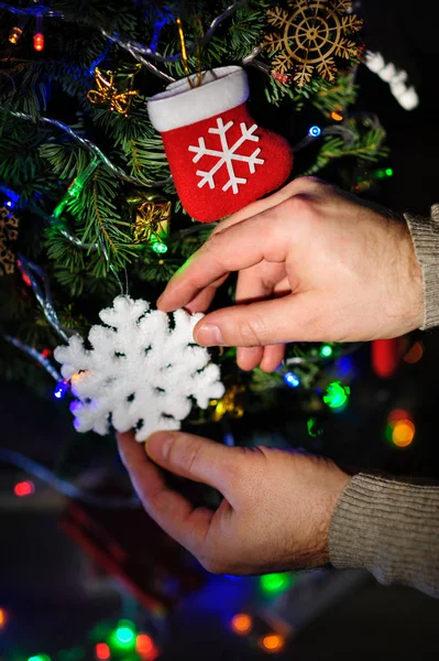 Man siert een kerstboom met speelgoed — Stockfoto