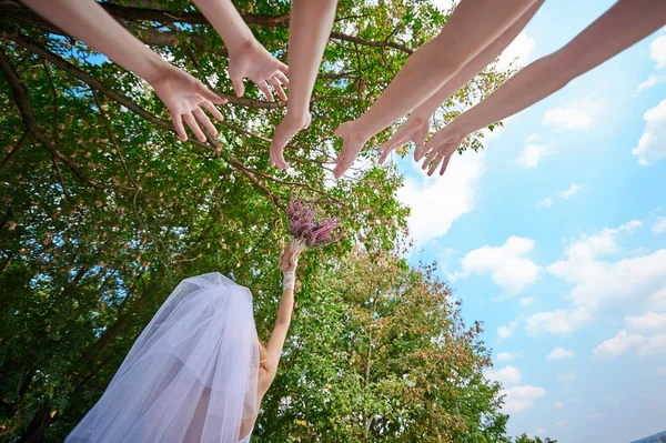 Noiva lança o buquê de casamento para mulheres jovens — Fotografia de Stock