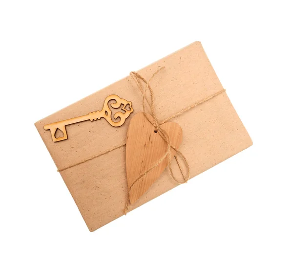 Caixa de papel kraft e coração de madeira sobre fundo branco — Fotografia de Stock