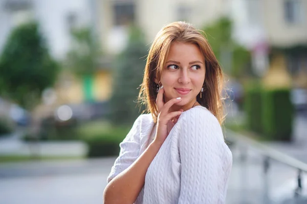 Jovem mulher sorridente posando no fundo da cidade — Fotografia de Stock