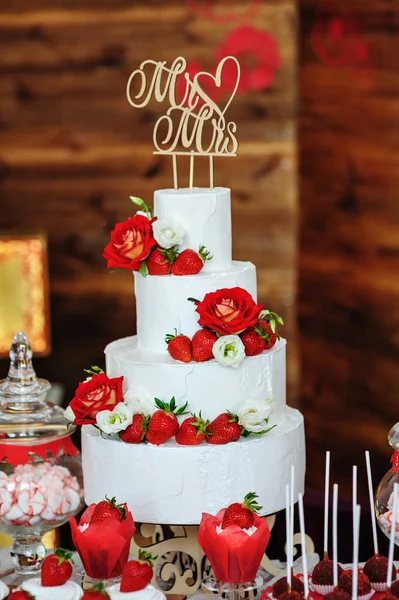 Hermoso pastel de boda de tres capas decorado con flores rojas — Foto de Stock