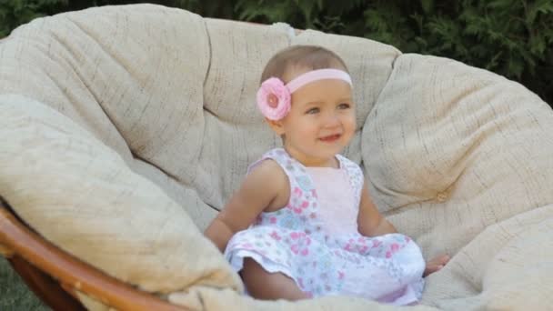 Kleines glückliches Mädchen sitzt auf der Couch — Stockvideo