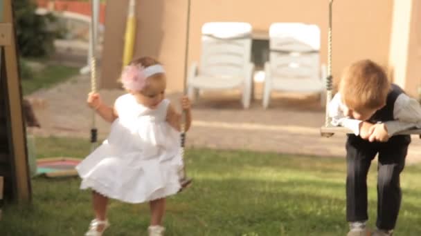 petit garçon et fille monter sur la balançoire 