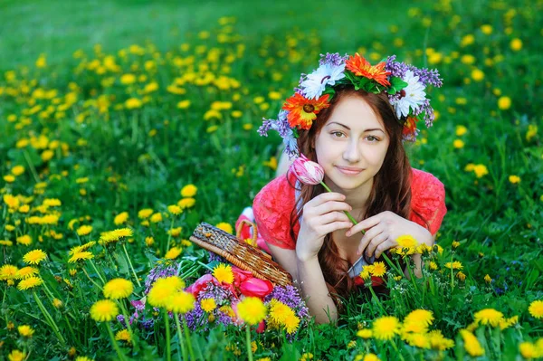 牧草地の草の上に横たわる赤いドレスの若い女性 — ストック写真