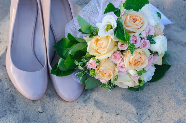 Buquê de casamento e sapatos na areia — Fotografia de Stock