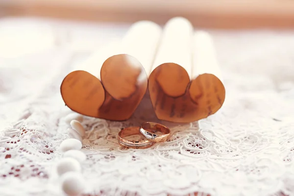 Guld vigselringar bruden och brudgummen på bakgrunden av hjärtan — Stockfoto