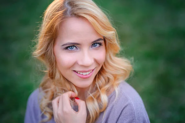 Bela jovem com maquiagem posando em um parque de verão — Fotografia de Stock
