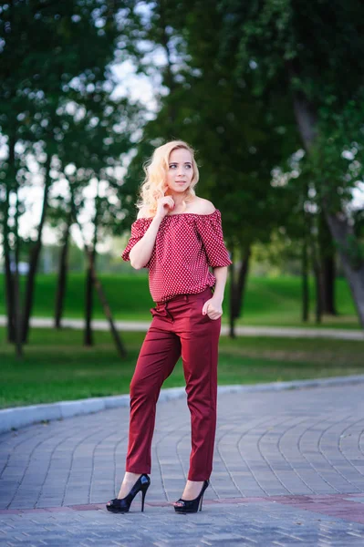 Beautiful young woman walking in a summer park — Stock Photo, Image