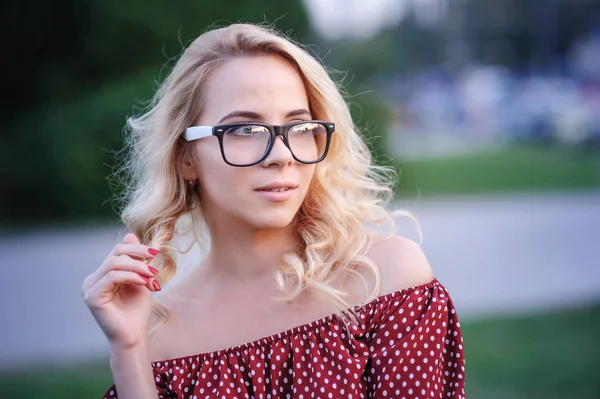 young woman in glasses on a background of lake