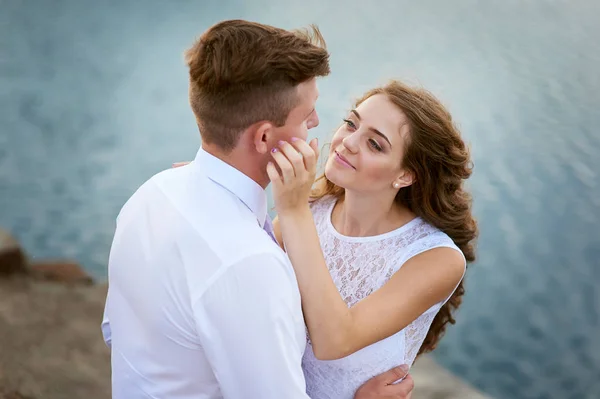 Sposa e sposo abbracciati al lago per una passeggiata — Foto Stock