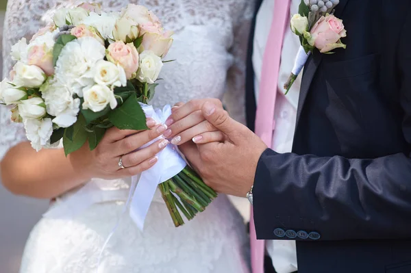 Noivo segura sua mão noivas e um buquê de casamento — Fotografia de Stock