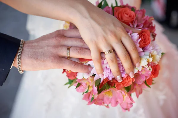 Mão de noiva e noivo com anéis no buquê de casamento — Fotografia de Stock