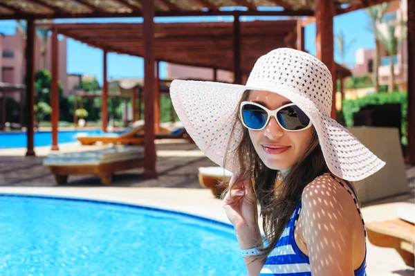 Güzel ve genç birbayan Resort havuz kenarında oturur — Stok fotoğraf