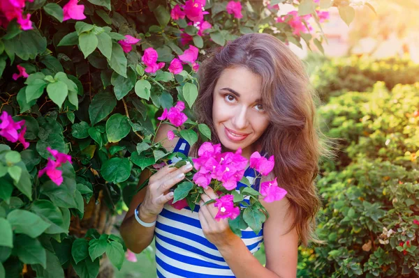 Beautiful young woman near the flowering bougainvillea — Stock Photo, Image