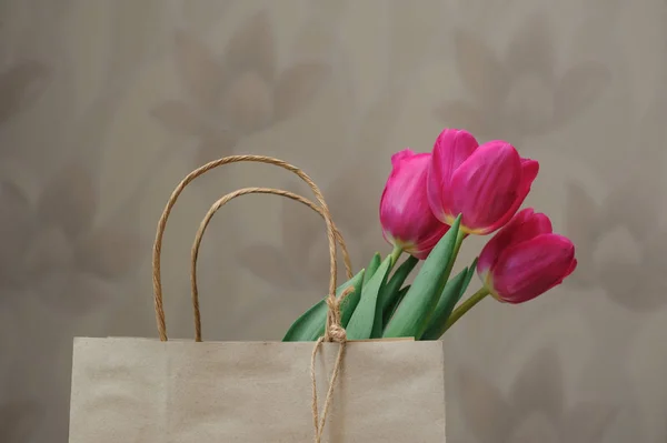 Ramo de tulipanes rojos en bolsa de papel — Foto de Stock