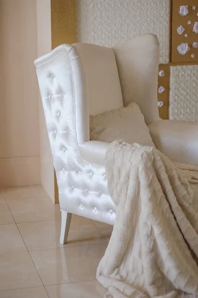 Bílá židle s dekou v ateliéru — Stock fotografie