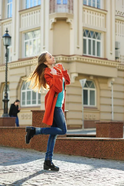 Bela jovem mulher de casaco andando pela rua — Fotografia de Stock