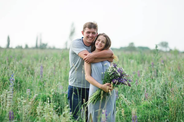 Ungt par embracing på sommaräng — Stockfoto