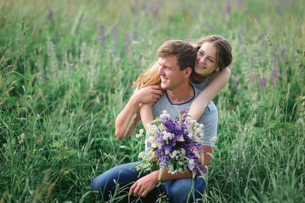 夏の草原に抱きしめる若いカップル — ストック写真