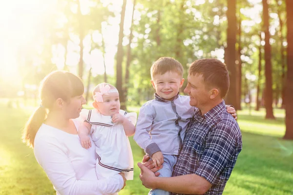 Jeunes parents avec enfants marchent dans le parc d'été — Photo