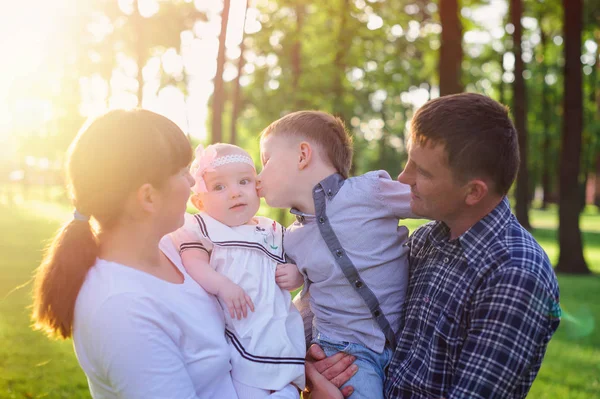 Jeunes parents avec enfants marchent dans le parc d'été — Photo